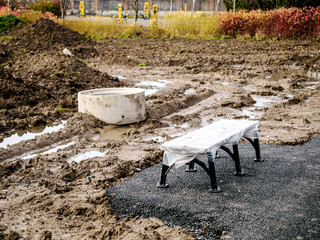 Metal bench installed, park renovation. Ground work in progress. Selective focus.