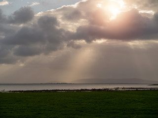 Sunset sky over Atlantic ocean, Galway bay, Burren mountains in the background. Nature landscape.