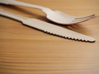 Wooden degradable fork and knife on a light wood table surface, Concept ecology and recycle issue.