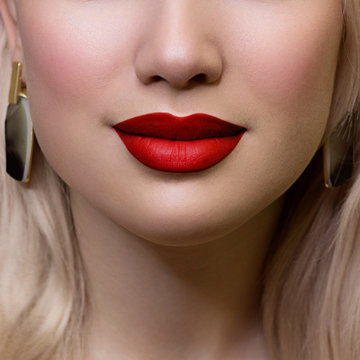Cosmetics, makeup and trends. Bright lip gloss and lipstick on lips. Closeup of beautiful female mouth with red and pink lip makeup. Beautiful part of female face. Perfect clean skin