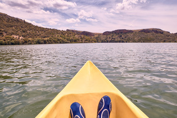 View of a man's feet while kayaking on the river