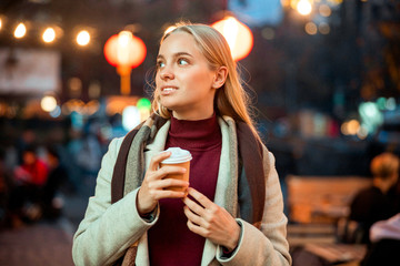 Pretty young lady spending time outdoors with coffee