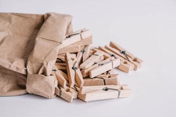 Wooden clothespins in paper bag on white background. View from above. Place for your text