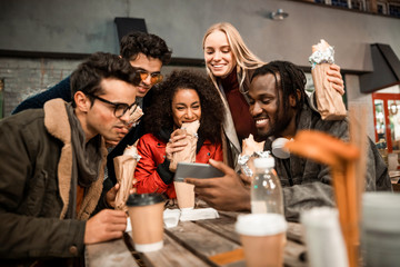 Happy young friends watching video on the phone