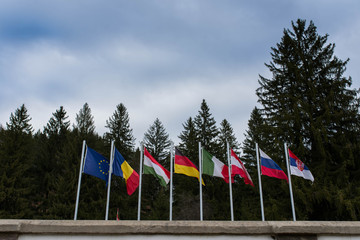 Fototapeta na wymiar Waving european flags in local international World War 1 and 2 memorial park in Transylvania, Romania.