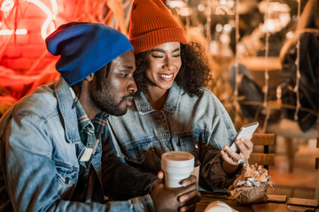 Happy man and woman looking at mobile phone