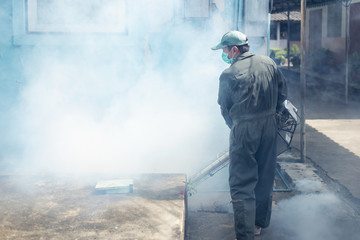 Man work fogging to eliminate mosquito for preventing spread dengue fever