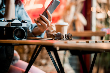 Cropped photo of female hand with mobile phone outdoors