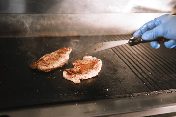 Cook prepares a hamburger.