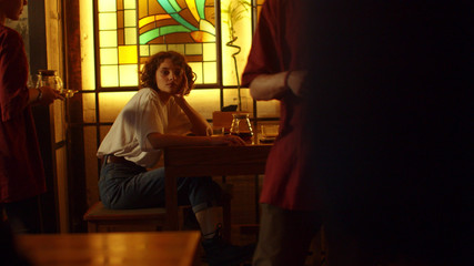 Girl sit at a table in a cafe and wait for someone