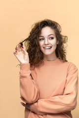 Portrait of a young beautiful woman wearing sweatshirt posing isolated over yellow background