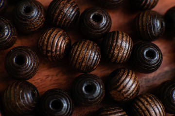 brown beads on a wooden tray and a white table