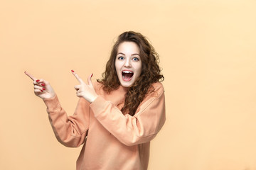 Obraz premium Portrait of a young beautiful woman wearing sweatshirt posing isolated over yellow background