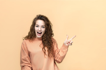 Portrait of a young beautiful woman wearing sweatshirt posing isolated over yellow background