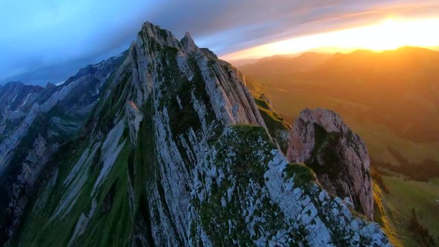 FPV drone view over the Alpstein ridge, in the Appenzell Alps, at sunset, on a moody summer evening, in Switzerland