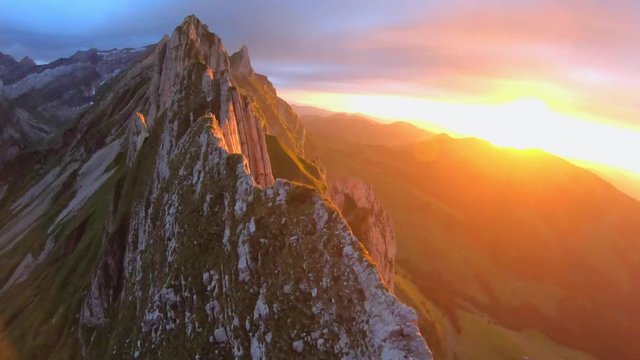 FPV drone shot panning over the Schaefler Ridge, at sunset, on a sunny summer evening, in Appenzell Alps, Switzerland