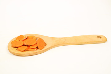Turmeric rhizomes in a wooden spoon isolated on a white background