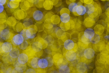 Defocused photography of colorful Christmas lights in night. Impressionism style. Twinkle of white, gold and blue lights. Suitable as background for miracle creative template