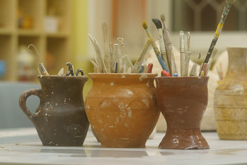 Workplace of the artist. There are clay jugs with tassels on the table. Concepts of creativity