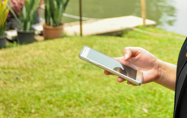 woman using phone in the garden to connections social media online.