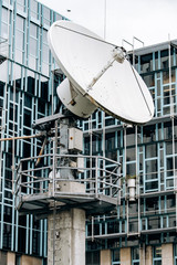 Parabolic satellite dish on the background of the building
