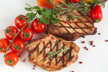 Grilled pork chops with vegetables-cherry tomatoes, peppers, parsley on a wooden Board. Isolate.