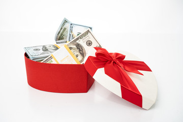 Bundle of dollars in heart gift box with bow isolated on white