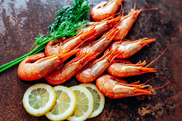 Fresh shrimp with lemon and dill on the red table.