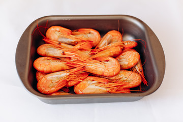 Bowl of fresh shrimp on white background