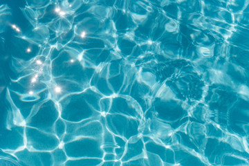 Fototapeta na wymiar Beautiful refreshing blue swimming pool water. Background of blue water in the pool