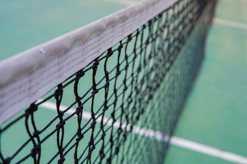 tennis net on a green tennis court