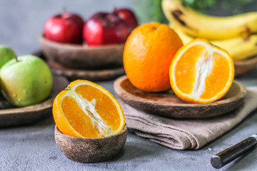 Photo of fresh orange on retro background. Slice of orange in front of fruits and vegetables. Half of the orange on wooden plate bowl. Sunkist. Summer. Image