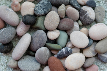Fototapeta na wymiar Folded sea pebbles collected on the shore of the sea