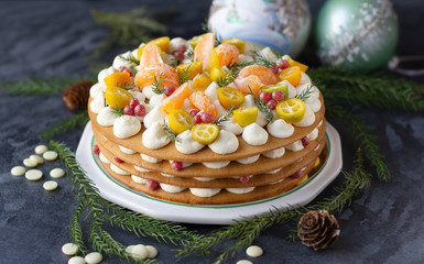 Obraz na płótnie Canvas Layered cake with white ganache cream decorated with sliced kumquat, mandarin, cranberries. Winter cake decoration, festive mood ....