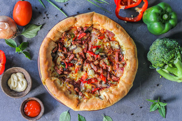 Photo of pizza on the table with ingredients around. Tasty pizza on the wooden background. Flat lay with top view. Italian pizza. Delicious pizza. Image