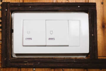 White double switch, controls light and water heater, close up shot. Modern switch on old wall.