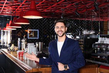 Young business owner standing near counter in his cafe
