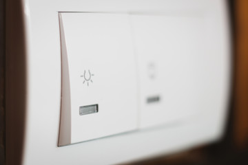 White light switch with icon on it, close up shot.