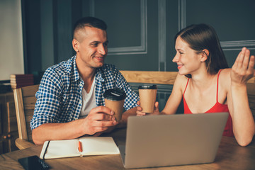 Cheerful couple working with laptop and talking