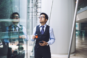 Asian businessman standing in office building hall