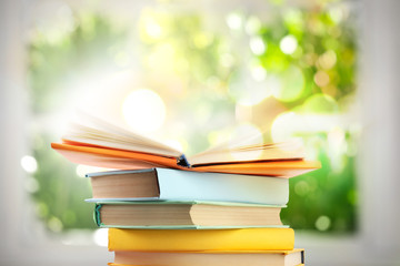Stack of colorful books on blurred green background