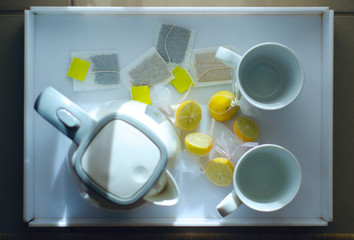 Kettle with mugs, lemon on hotel room, top view
