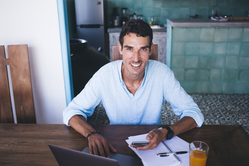 Cheerful man working on article at home