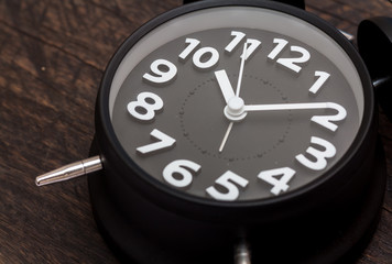 Black bell clock on wood background,selective focus