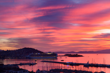 Fototapeta premium Red sky sunset at Kusadasi Turkey Harbour with Guvercin Adasi castle and cruise ship on the Aegean Sea with Samos Island