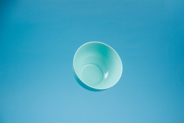 A blue ceramic mattle deep bowl for breakfast flying on blue background.