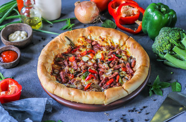 Photo of pizza on the table with ingredients around. Tasty pizza on the wooden background. Homemade pizza. Italian pizza. Delicious pizza. Image