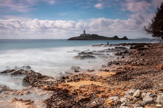 The beautiful coast shore of the island Mallorca in spain with an old and weathered lighthouse - longexposure photography