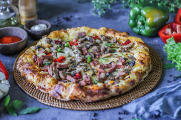 Photo of pizza on the table with ingredients around. Tasty pizza on the wooden background. Homemade pizza. Italian pizza. Delicious pizza. Image