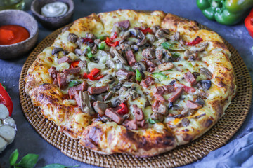 Photo of pizza on the table with ingredients around. Tasty pizza on the wooden background. Homemade pizza. Italian pizza. Delicious pizza. Image